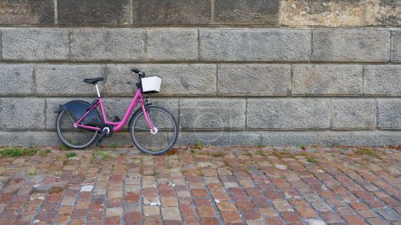 Téléchargez les photos : Vélo rose stationné sur un mur sur les rives de la rivière Vltava à Prague, République tchèque - en image libre de droit
