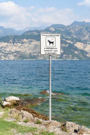 Foto de Firme en la orilla del lago Grada cerca de Malcesine en Italia. Traducción: Los perros deben ser mantenidos en una pista - Imagen libre de derechos