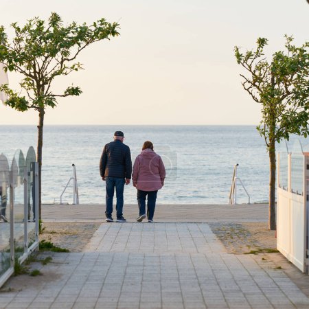 Photo for Kuehlungsborn, Germany  May 24, 2023: elderly couple on the beach promenade of Kuehlungsborn in Germany with a view of the Baltic Sea - Royalty Free Image