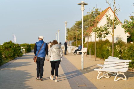 Photo for Kuehlungsborn, Germany  May 26, 2023: Couple walking on the beach promenade of Kuehlungsborn on the German Baltic Sea coast - Royalty Free Image