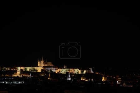 Silhouette der bei Touristen sehr beliebten Stadt Prag mit der beleuchteten Prager Burg bei Nacht mit Textfläche                                