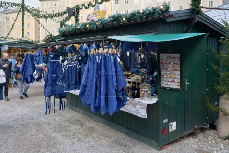 Photo for Salzburg, Austria  December 25, 2023: Stall selling Blaudruck, indigo-dyed linen and cotton fabrics at the Christkindlmarkt, Christmas market in Salzburg, Austria - Royalty Free Image