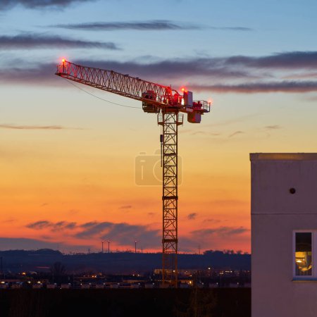   Grue sur un chantier de construction le soir au coucher du soleil à Magdebourg en Allemagne                              