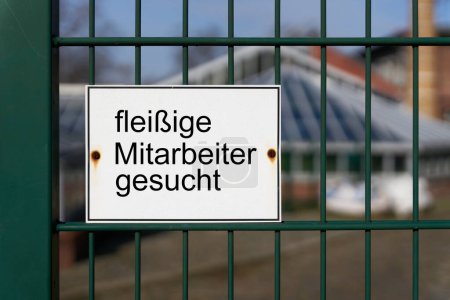    Señal con la inscripción alemana fleissige Mitarbeiter gesucht, como una indicación de la escasez de especialistas capacitados en Alemania. Traducción: Se buscan empleados trabajadores                            