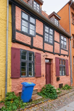   Wohnhaus in der historischen Altstadt von Stralsund in Deutschland mit einem blauen Mülleimer für Recyclingpapier                             
