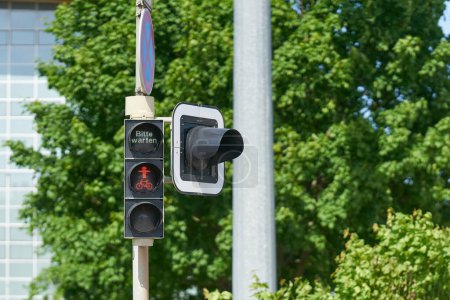 semáforo rojo en el centro de la ciudad de Magdeburgo con la letra alemana bitte warten. Traducción: por favor espere                               