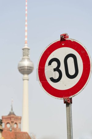     Traffic sign with the 30 km/h speed limit in Berlin with the television tower in the background                           