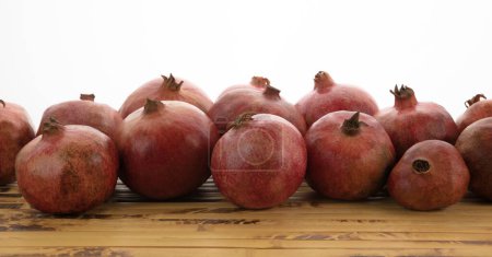 Photo for Ripe pomegranates on a bamboo mat - Royalty Free Image