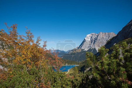Photo for Autumn landscape Tirol, lake Seebensee and Zugspitze mountain, view from the hiking trail. blue sky with copy space - Royalty Free Image