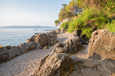 Foto de Playa de baño con piedras de grava y rocas en la playa Moscenicka Draga, en el sol de la mañana - Imagen libre de derechos
