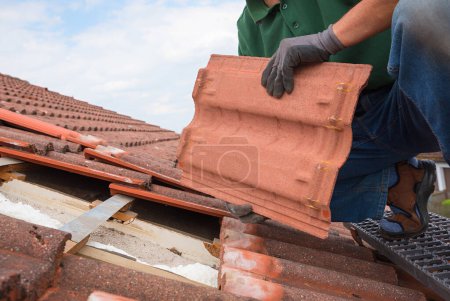 Photo for Man remove old roof shingle to replace with new ones. renovation at home - Royalty Free Image