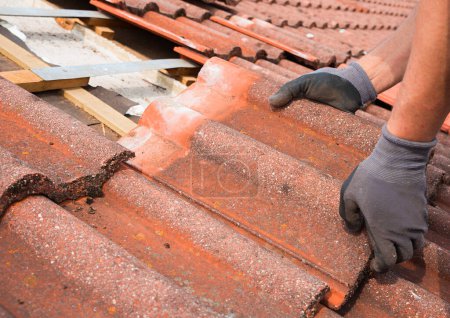 Photo for Man remove old roof shingle to replace with new ones. closeup shot of renovation action - Royalty Free Image