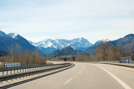 Téléchargez les photos : Conduire à l'autoroute à Garmisch en saison hivernale. arbres nus au bord de la route - en image libre de droit