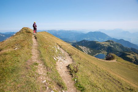 Foto de Joven en el sendero de senderismo Rofanspitze, mirando al lago Zireiner See y el valle de Inntal, paisaje austriaco en otoño. cielo azul con espacio de copia - Imagen libre de derechos