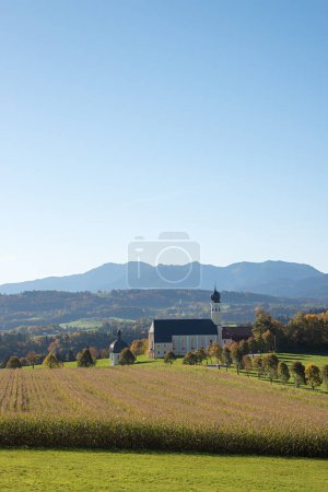 schöne Wallfahrtskirche Wilparting, Bayerische Alpen, Kornfeld und Allee, herbstliche Landschaft Oberbayern. blauer Himmel mit Kopierraum