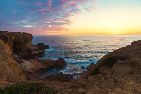 sinking sun over atlantic ocean algarve, rocky cliffs carrapateira. sunset scenery portugal landscape