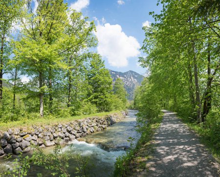 Idyllischer Fußweg unter Bäumen, entlang der Rottach, Quelllandschaft Oberbayern. in der Nähe von Touristenziel Tegernsee