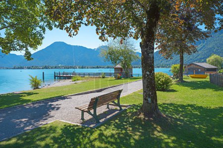 área recreativa Abwinkl, lago Tegernsee con césped de baño y muelle del barco. paisaje bavariano en verano