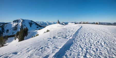 snowy Wallberg summit with chapel and view to Setzberg mountain, upper bavarian tourist destination Rottach-Egern