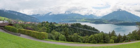 panoramic landscape above tourist resort Sigriswil, view to rope bridge, mountains and lake Thunersee, bernese Oberland destination. 