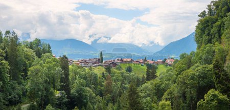 Blick auf Tourismusort Sigriswil und wolkenverhangene Berner Alpen, Landschaft Schweiz