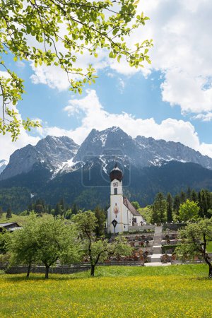 idyllische Frühlingslandschaft mit katholischer Kirche und Friedhof, Grainau Oberbayern
