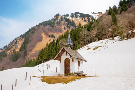 kleine Kapelle Alpe Oberau, Trettachtal, verschneiter Hang. Allgäuer Alpen im März