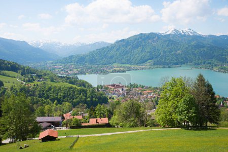 view from hiking route Neureuth, above lake Tegernsee, idyllic spring landscape bavarian alps. tourist resort Tegernsee with castle.