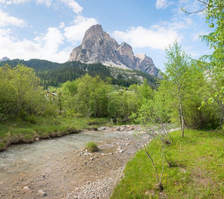spring landscape with River Gader and view to Sassongher mountain, tourist resort Corvara, south tyrol. Dolomites alps.