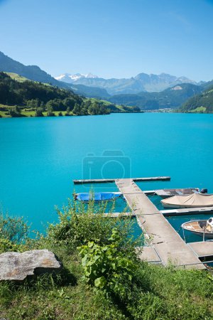 turquoise lake Lungernsee, with boardwalk and boats, landscape switzerland, canton Obwalden