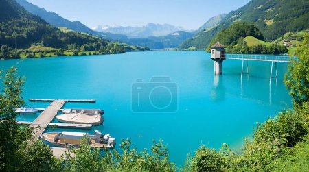 turquoise lake Lungernsee, with boardwalk and boats, observation tower in the water. landscape switzerland, canton Obwalden