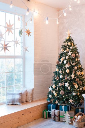 Photo for Interior of modern studio living room with comfortable sofa decorated with Christmas trees and gifts. Vertical image - Royalty Free Image
