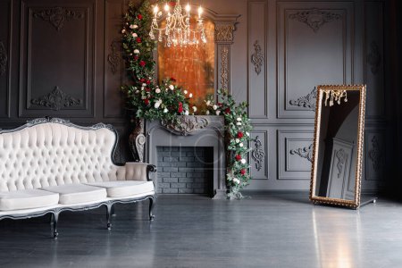 Foto de Black classical room interior with a vintage sofa, chandelier, mirror and fireplace decorated with flowers - Imagen libre de derechos