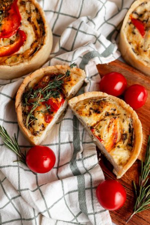 A delectable tomato and herb tart showcasing fresh cherry tomatoes, baked perfectly on a rustic wooden board