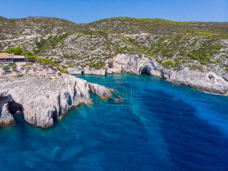 Drone shot of Zakynthos island with beautiful turquoise Ionian sea and limestone cliffs and cave at Porto Limnionas beach during daytime near Blue Caves in Greece