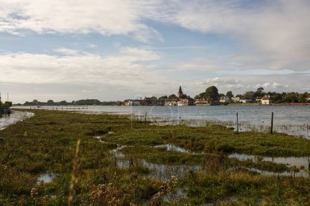 Waterfront at Bosham in Chichester Harbour, West Sussex, England. High tide. Unrecognisable people.