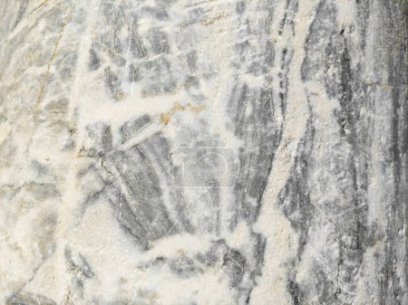La textura de una piedra de mármol gris con venas, grietas e inclusiones