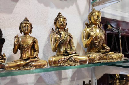 Photo for Decorative metal figurines of Buddha in a meditative pose on a shop window - Royalty Free Image