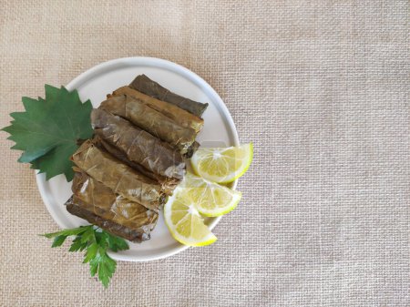 Traditional oriental Turkish dolma made of grape leaves stuffed with rice on a decorative plate
