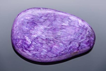 Photo for Charoite tumblestone - Very sharp and detailed photo of a rare and beautiful stone that can be only found in the Republic of Sakha (Yakutia, Russia). - Royalty Free Image