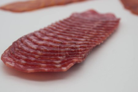 Artisanal salami slices fanned out on rustic wood