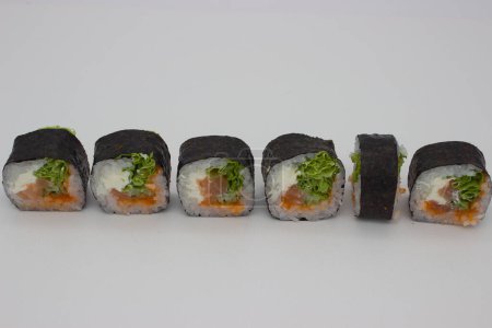 Ein köstliches Arrangement von Lachs-Sushi-Rollen mit knusprigem Salat und Reis, präsentiert in einem sauberen weißen Hintergrund.