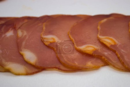 Thinly sliced premium cured ham with visible marbling
