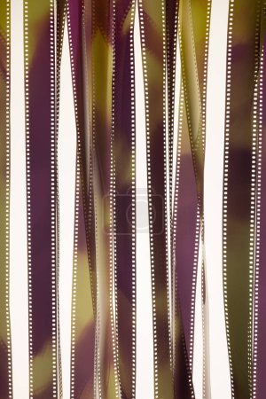 Téléchargez les photos : Fragments voilés de film 35 mm sur surface blanche. Concept de cinématographie. - en image libre de droit