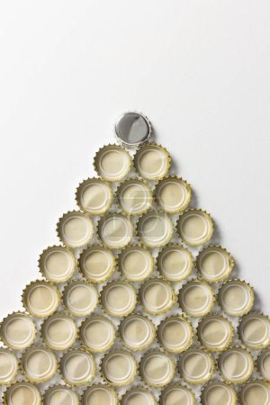 Set of soda bottle caps forming a triangle with one of them standing out above all the others. Outstanding leader concept.