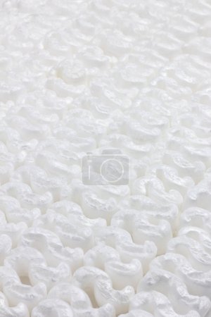 Texture formed by the regular repetition of wavy white polystyrene pieces.