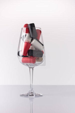 Copa de vino llena de tapones de botellas de vino abiertas.