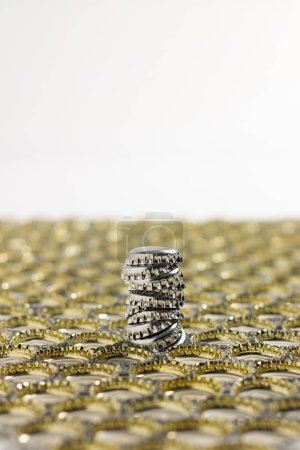 Column composed of bottle caps positioned downward protruding from the surface formed by many other caps positioned downward.