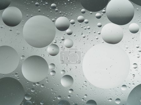 Grey scale abstract with oil droplets in water, showcasing a serene monochromatic pattern.