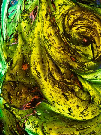 Une image présentant une combinaison lumineuse et tourbillonnante de vert et de jaune avec des gouttelettes réfléchissantes, créant un design abstrait.